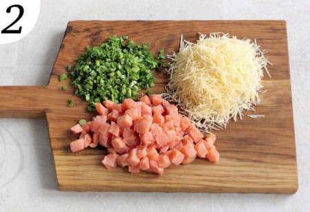 Нарежьте рыбу мелкими кусочками. Измельчите зеленый лук. Натрите сыр на мелкой терке.
