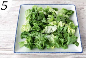 Нарежьте салатные листья подходящими для еды кусочками и выложите на большое, лучше прямоугольное, блюдо.
