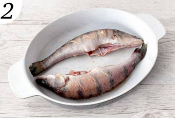  Сделайте на рыбе косые надрезы, посолите и поперчите, в брюшко положите петрушку. Смажьте кожу 1 ст. ложка  сливочного масла и поместите рыбу в большую форму для запекания. 